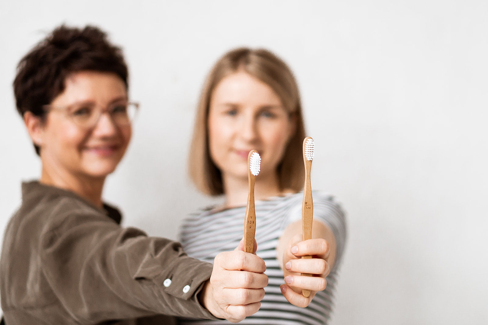 GreenFOR Gründerinnen Manuela Büttner und Franziska Seebauer halten Bambuszahnbürsten hoch